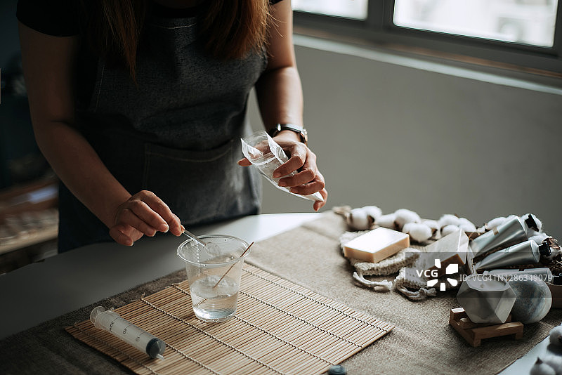 亚洲华人女性将小苏打倒入水杯图片素材