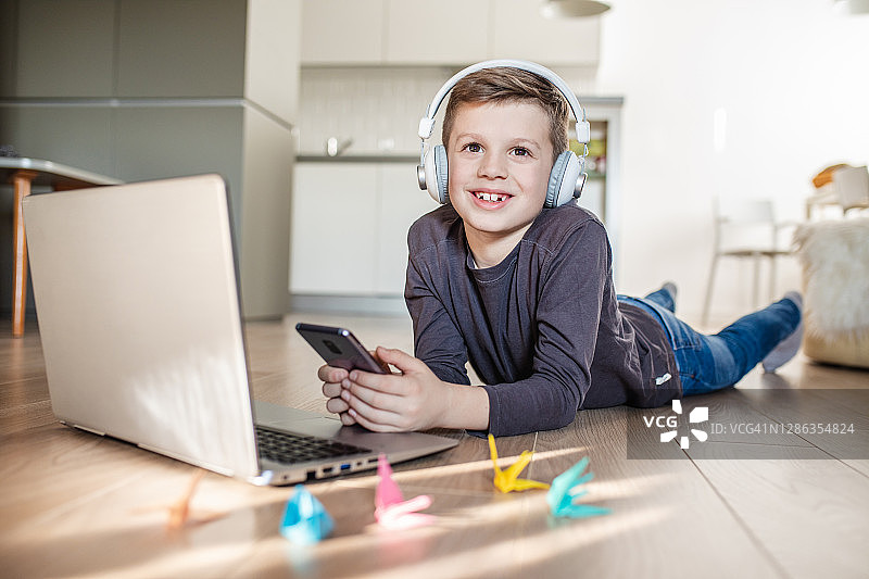 可爱的男孩在家使用科技产品图片素材