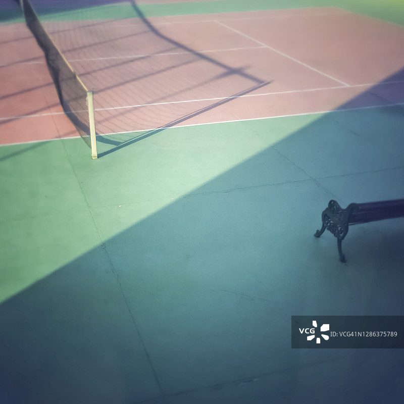 带球网、阴影和长椅的网球场图片素材