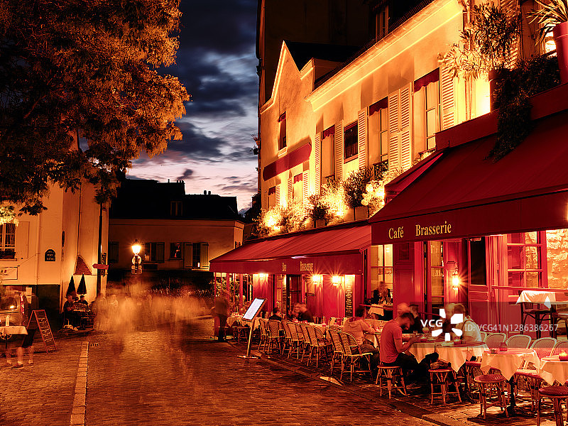 人们坐在巴黎的咖啡馆和餐馆外图片素材