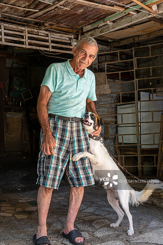古巴老年男人和他的混种宠物犬图片素材