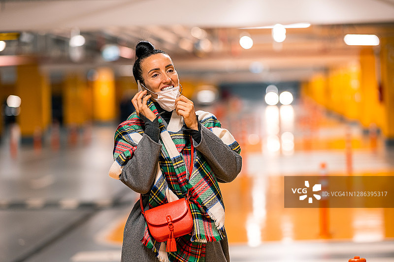 快乐的女人打电话并摘下防护口罩图片素材