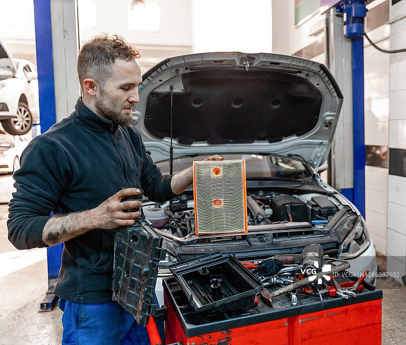 汽车修理工更换汽车空气滤清器图片素材