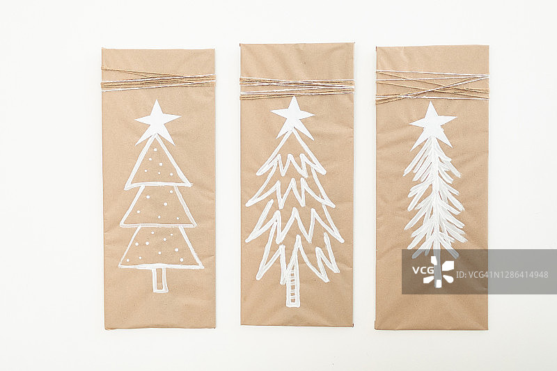 牛皮纸上的三个水彩圣诞树图片素材