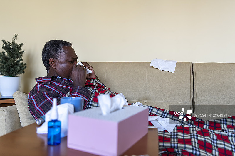 患病的老年非洲裔男子感冒流鼻涕图片素材