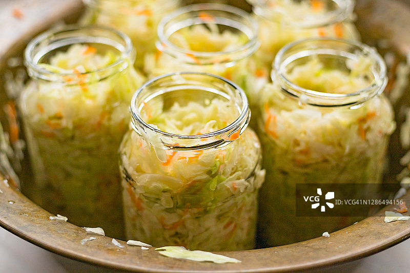 铜碗和玻璃罐中的腌酸菜：乳酸菌发酵的白菜图片素材