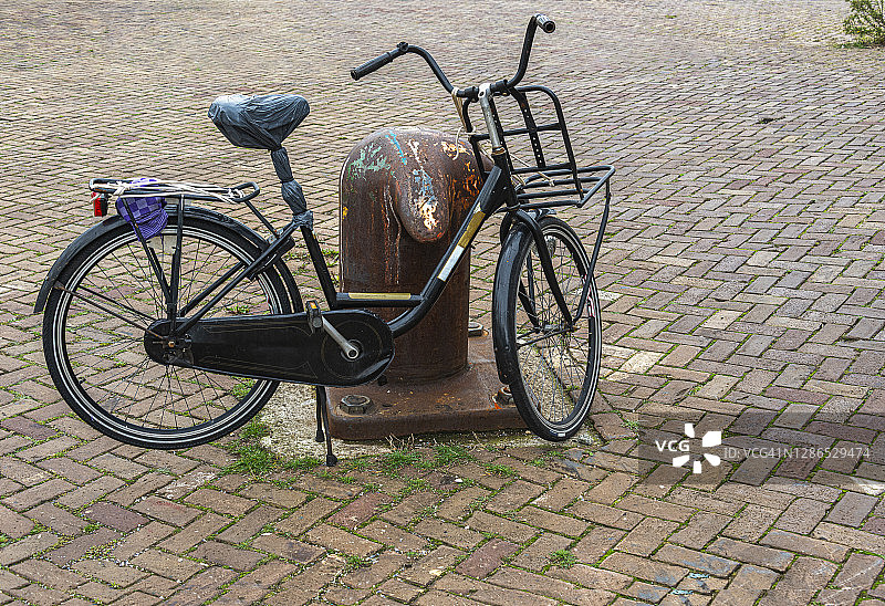 前轮上方带有行李架的黑色荷兰老式自行车图片素材