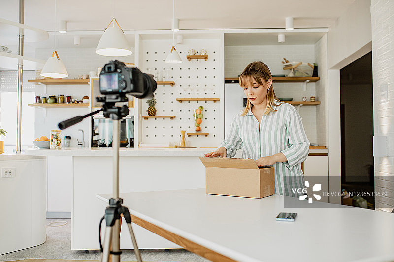 年轻女子在网上直播拆包裹图片素材