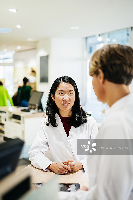 两位药剂师在柜台交谈图片素材