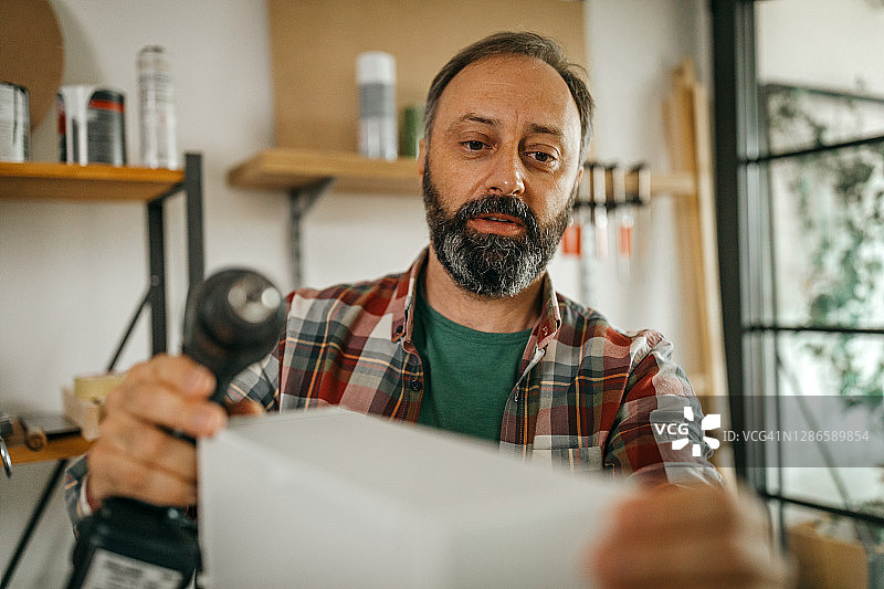 中年男人在家享受他的DIY项目图片素材