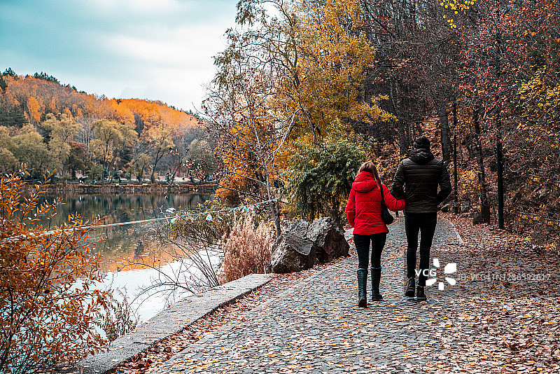 秋季情侣在森林湖边散步图片素材
