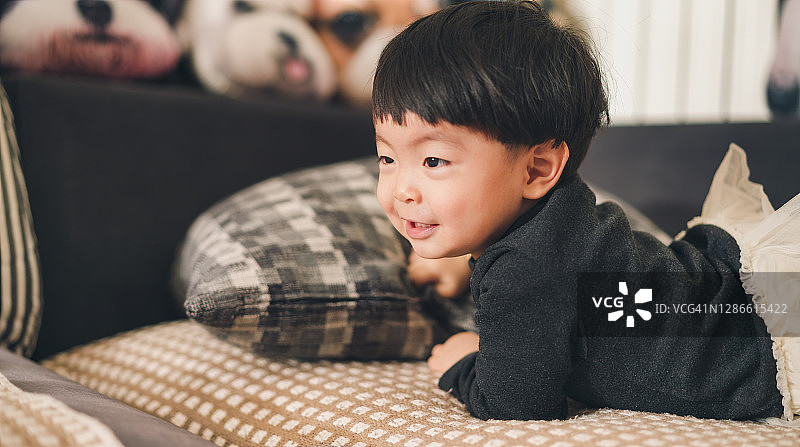 快乐的女孩躺在家里沙发上图片素材