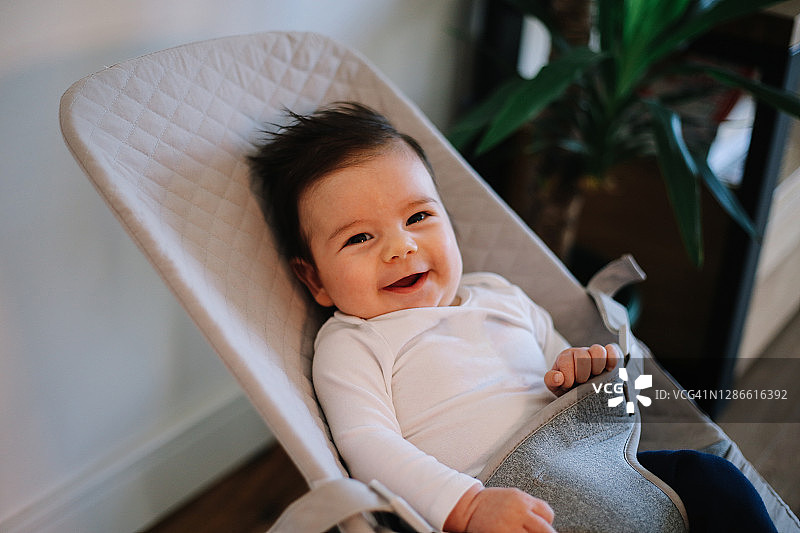 在摇椅上面带微笑的小男婴图片素材