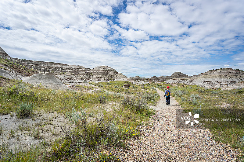 可爱的红发男孩在加拿大艾伯塔省恐龙省立公园恶地徒步图片素材
