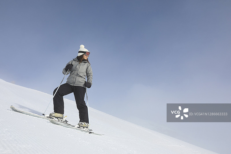 业余冬季运动：年轻女子在意大利多洛米蒂阳光明媚的滑雪胜地滑雪图片素材