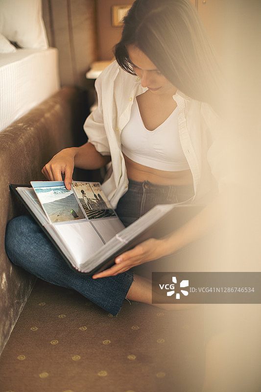 年轻漂亮的女人在看相册图片素材