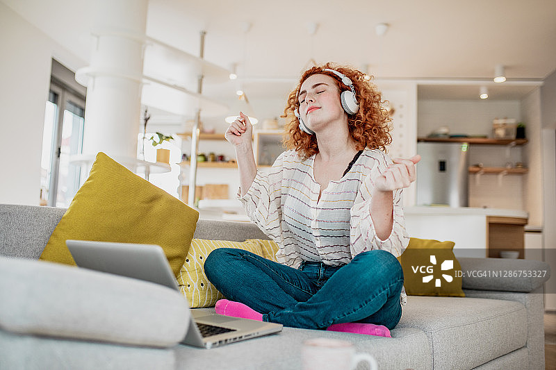 在家使用笔记本电脑和耳机放松图片素材