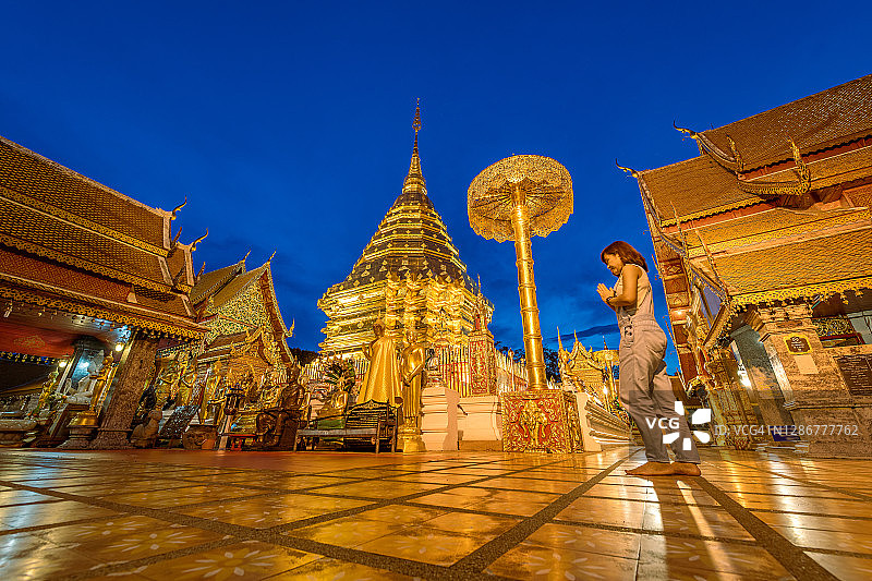 在清迈帕拉寺旅游的妇女在标志性历史地标前举手祈祷，该寺庙位于泰国北部省份图片素材