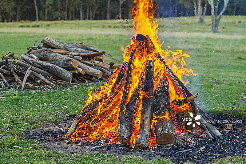绿色田野中燃烧的经典篝火图片素材