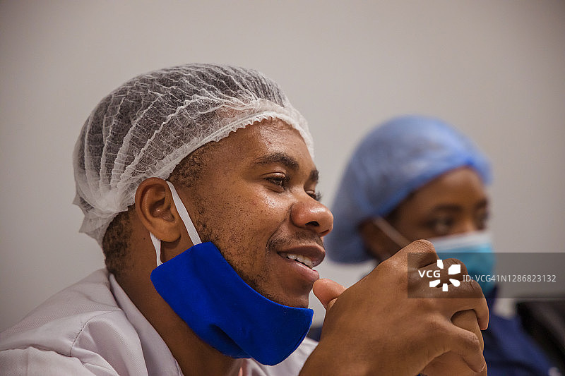 新冠疫情期间在会议室开会的赞比亚工厂工人图片素材