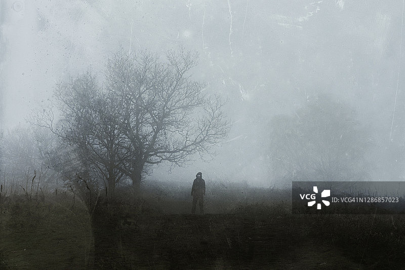 雾天山顶上发光的蒙面人图片素材