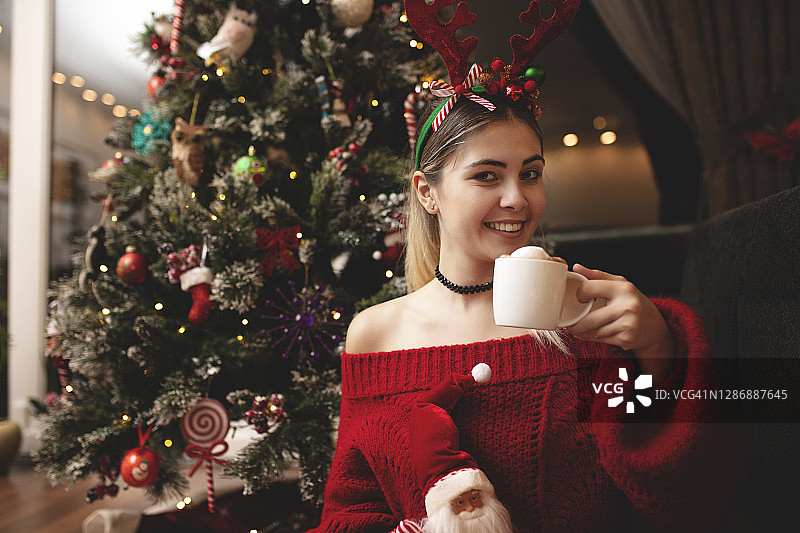 疫情期间，年轻女子在圣诞节独自在家喝热巧克力图片素材