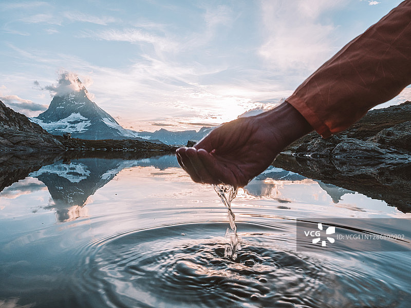 手捧马特洪峰山下湖水的细节图片素材
