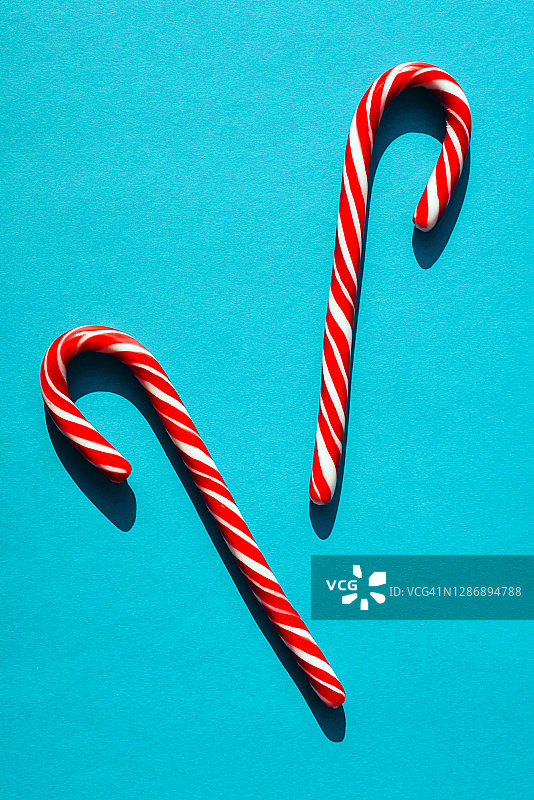 浅蓝色背景上的拐杖糖，带有强烈阴影图片素材