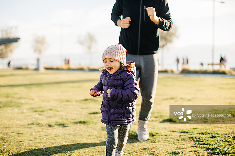 年轻男子和他的小女儿在公园里跑步图片素材