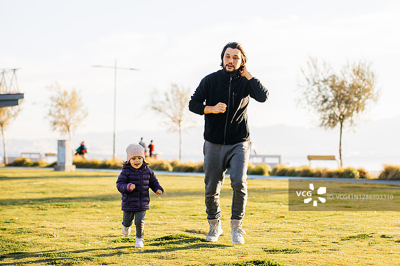 年轻男子和他的小女儿在公园里跑步图片素材