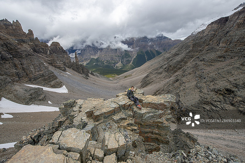 在加拿大阿尔伯塔路易斯湖附近，在Larch Valley Trail哨兵通道附近休息的孤独男孩图片素材