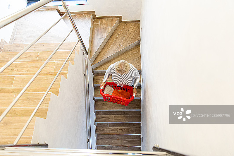 中年妇女拿着洗衣篮图片素材