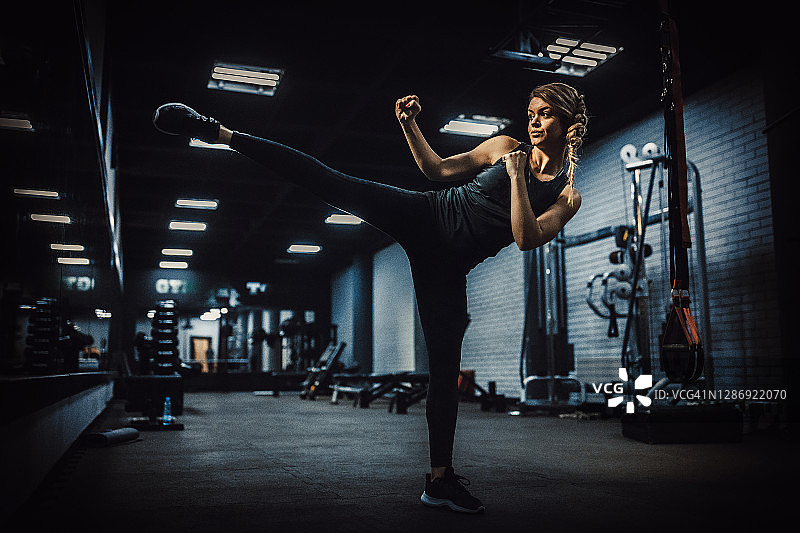 在健身房里摆出战斗姿势的健壮女人图片素材