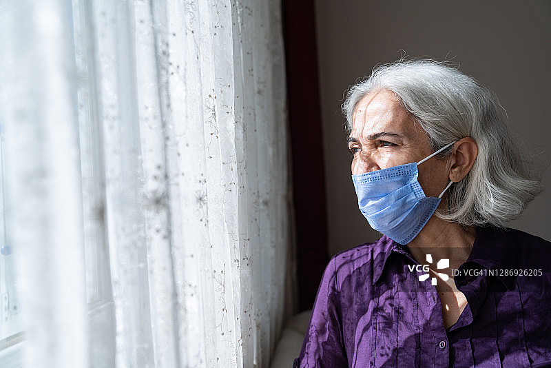 戴防护口罩的老年妇女肖像图片素材