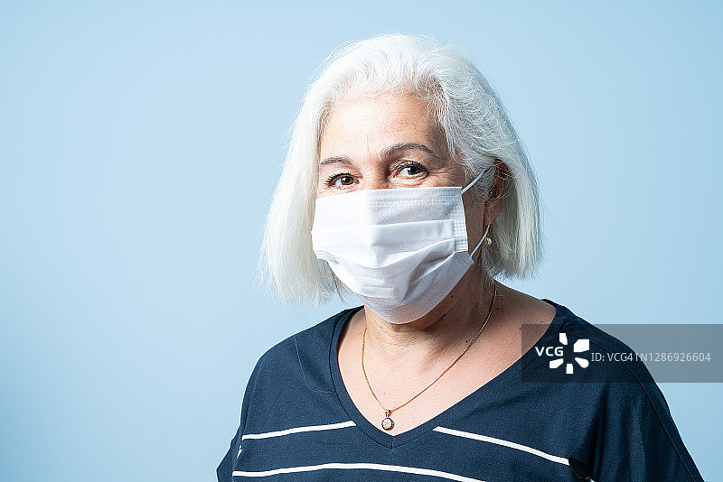 戴防护口罩的灰发年长女性肖像图片素材