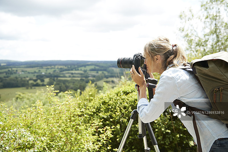 积极的老年妇女在晴天用相机拍摄自然风光图片素材