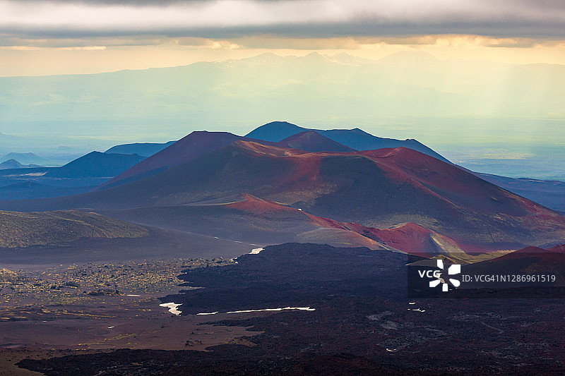 堪察加半岛壮丽的山地景观：熔岩平原，金色日落时分托尔巴奇克火山喷发区的火山渣锥图片素材
