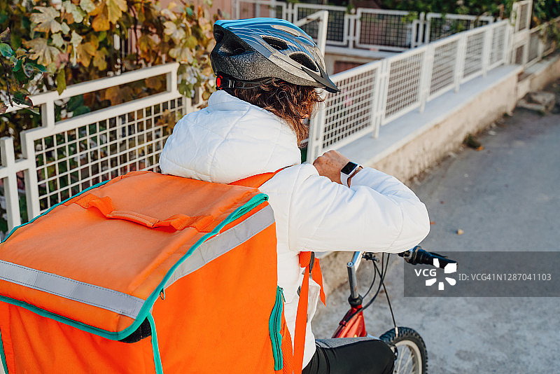 年轻女子骑自行车送外卖图片素材