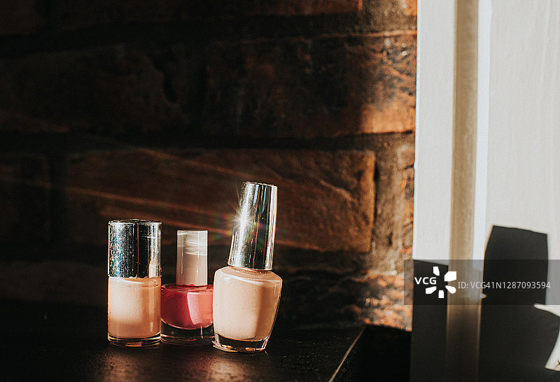 黑色背景和砖墙上的粉色指甲油图片素材