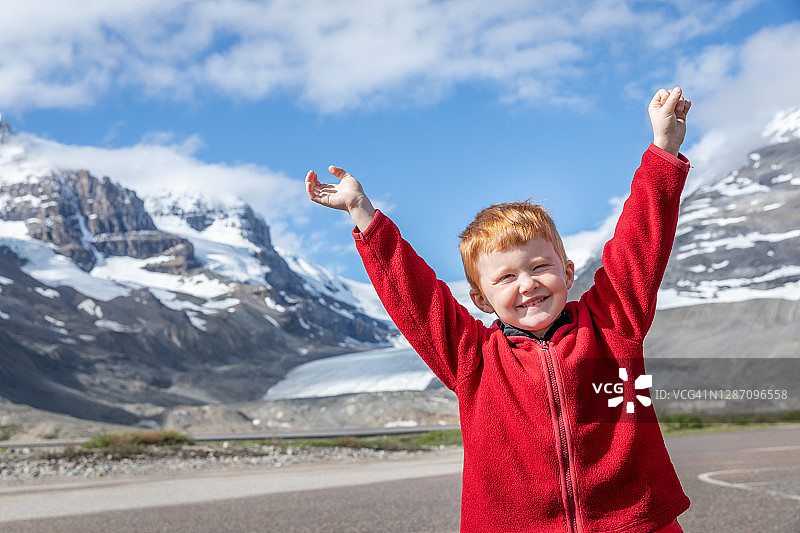 快乐可爱的红发男孩在哥伦比亚冰原举起手臂图片素材