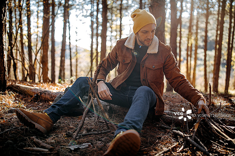 在森林里准备篝火的年轻男人图片素材