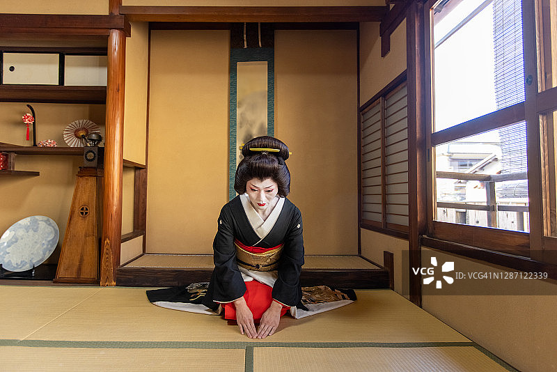身穿黑金和服的日本艺伎在日式房间问候图片素材