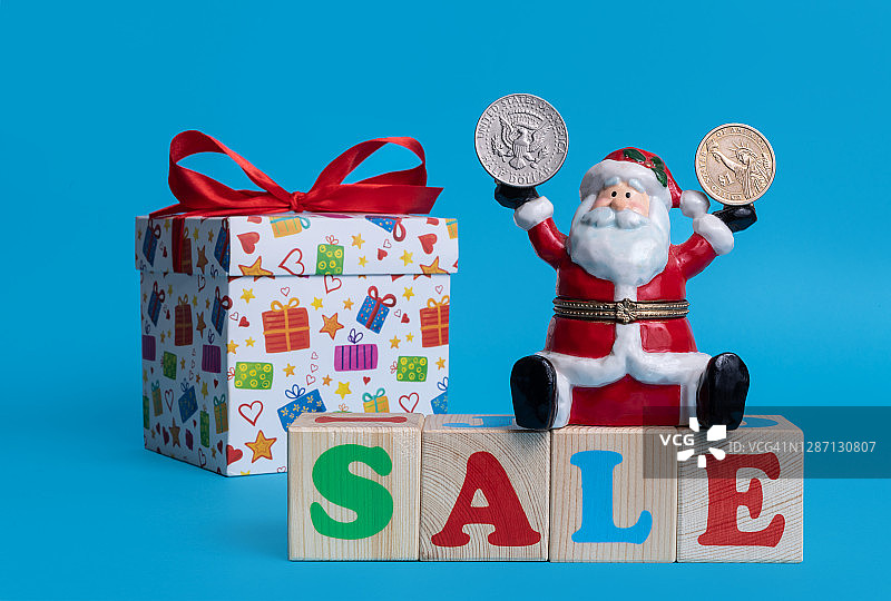 陶瓷圣诞老人玩具与促销字母方块及美元硬币图片素材