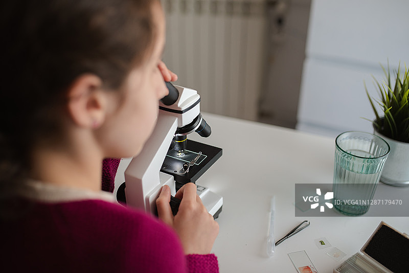 房间里小女孩使用显微镜特写图片素材