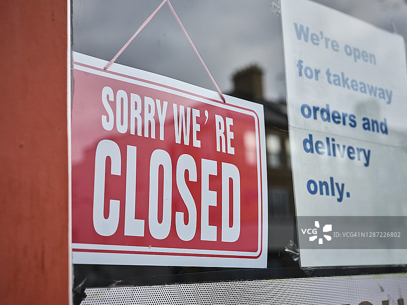 伦敦北部商业街上展示新冠疫情标牌的停业店铺图片素材