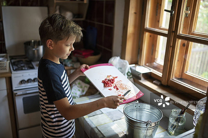 小男孩收集有机废物到桶里图片素材