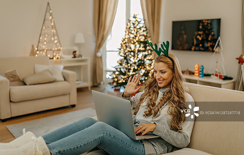 圣诞节期间在家工作的年轻女人图片素材