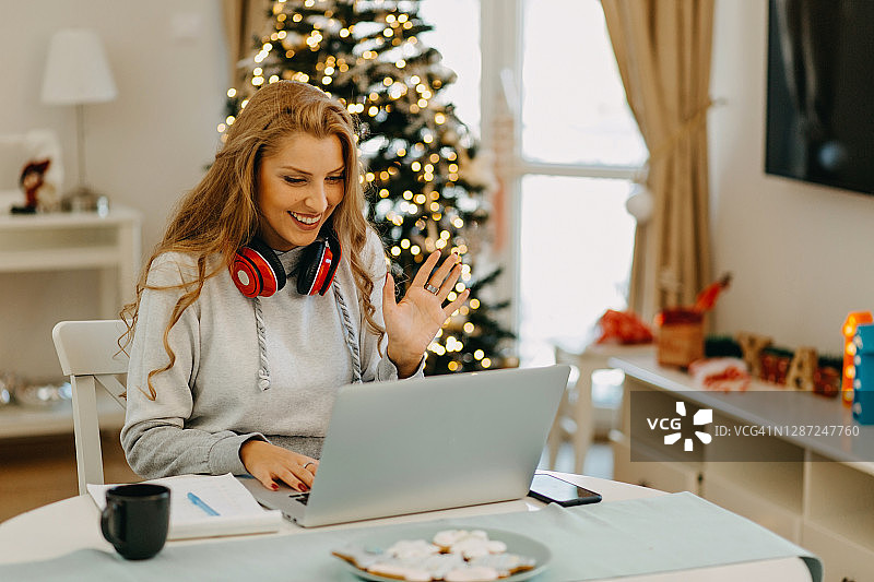 圣诞节期间在家工作的年轻女人图片素材