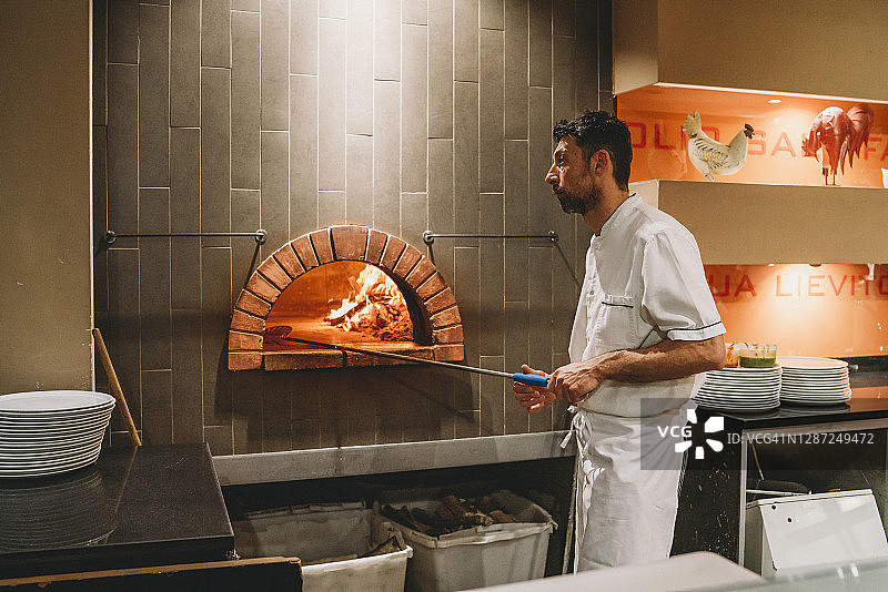 披萨厨师在烤箱中烤披萨图片素材