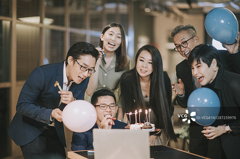 华人同事们通过笔记本电脑视频会议庆祝生日图片素材